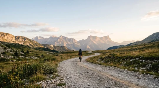 Vue panoramique d'un chemin de gravier longeant un col de montagne français avec espace négatif pour texte